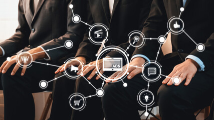 A group of professionals in suits at a business meeting, surrounded by digital icons representing advertising strategies and connectivity in a modern marketing landscape. Amity