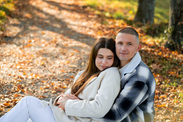 Fototapeta premium Portrait of a young happy couple in love in an autumn yellow park. Enjoying life.