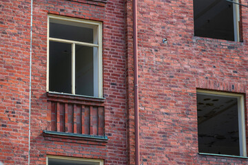 Old red brick building with empty windows.