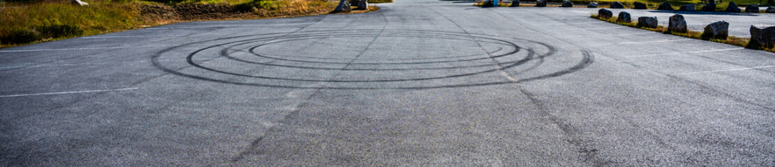Empty parking lot with circular tire skid marks.