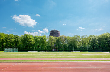 Outdoor sports field in Hamburg’s Stadtpark with running track and throwing cages, backed by the iconic Planetarium. Captured on a bright summer day.