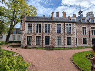 Historic palace building with patterned facade and garden