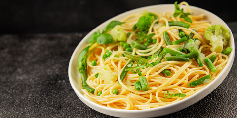 Spaghetti vegetables green peas, broccoli, string beans, kohlrabi vegetarian pasta tasty snack fresh delicious gourmet food background on the table rustic top view copy space vegan food