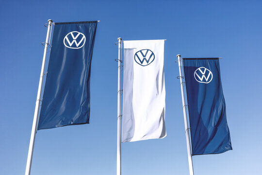 Poznan, Poland - September 28, 2023. Volkswagen logo on flags waving against a blue sky background.