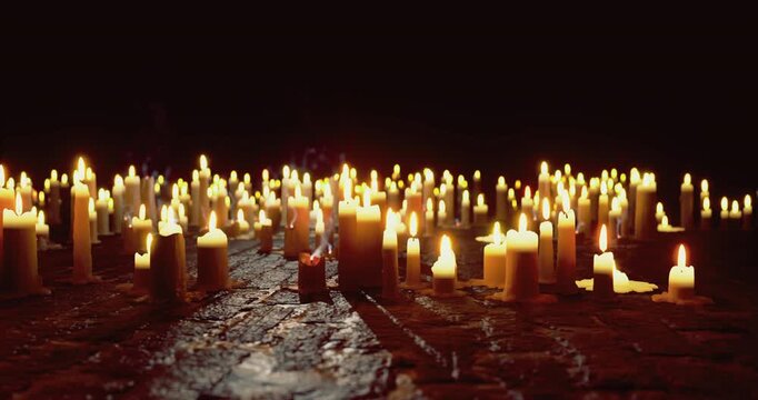 Flickering candles arranged on a rustic floor create a serene atmosphere at night, casting soft shadows and a warm glow in the dimly lit environment.