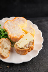 Washed rind cheese soft cheese with orange rind munster french cheese tasty snack fresh delicious gourmet food background on the table rustic top view copy space