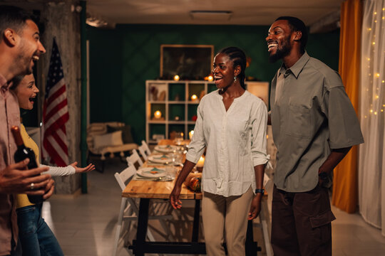 Friends arriving at thanksgiving dinner party with american flag