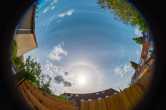 Fisheye view of a circular halo and parhelic circle over a city neighbourhood.