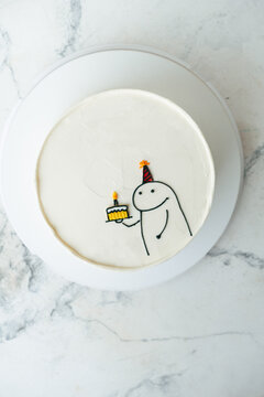Naklejki Birthday cake with funny meme drawing on the white marble background