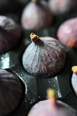 Close-up of fresh ripe purple figs with water drops. Exotic Mediterranean fruit, perfect for healthy eating, vegan diet, gourmet cooking, and natural food backgrounds.