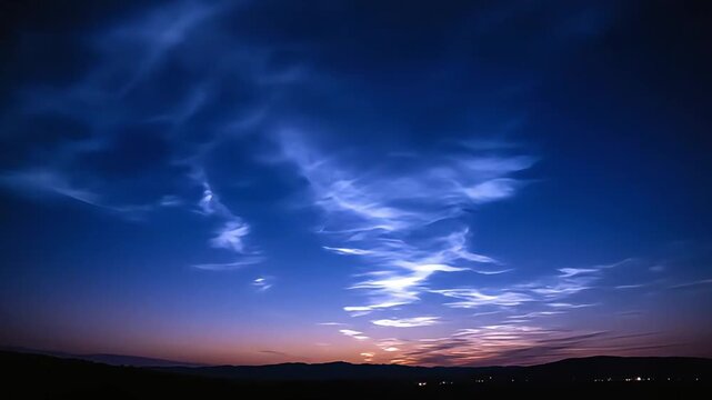 Noctilucent clouds over a dark horizon at twilight.