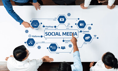 A diverse group of professionals collaborates around a table, analyzing social media strategies represented by various icons and elements of digital communication and marketing. Amity