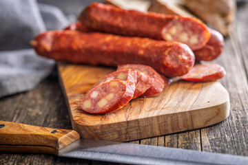 Sliced smoked ​​sausage on cutting board.