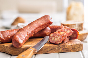 Sliced smoked ​​sausage on cutting board.
