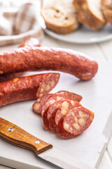 Sliced smoked ​​sausage on cutting board.