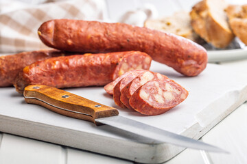 Sliced smoked ​​sausage on cutting board.