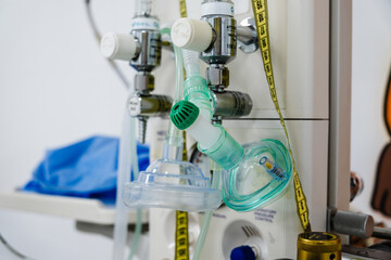 Oxygen mask hanging on a ventilator machine, ready to provide respiratory support in a hospital or clinical setting, ensuring patient safety and well-being