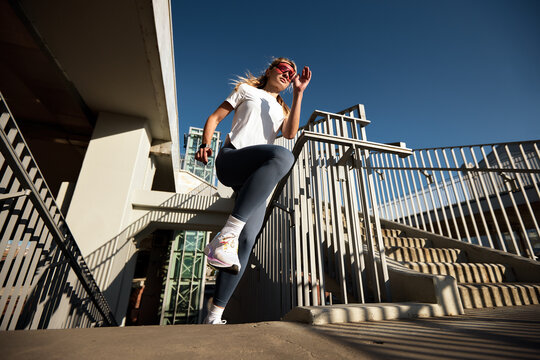 Active woman outdoor exercising on stairs in urban environment daytime