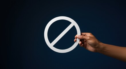 Hand holding a white prohibition sign. Concept of restriction, ban, or no entry. Visual for rules, warning, and forbidden actions on dark background.