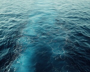 High-angle view of a dark blue ocean, with a wake