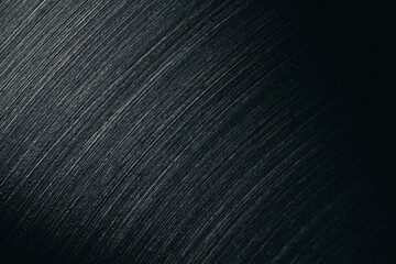 Close-up of brushed stainless steel surface showing fine diagonal lines and metallic texture, often...