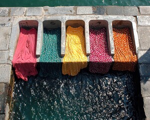 Colorful fabrics drying in a water channel