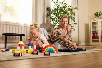 Young woman with child playing and creating together in a cozy living room