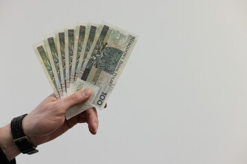 Man holding a fan from 100 bills banknotes of Polish zloty. 