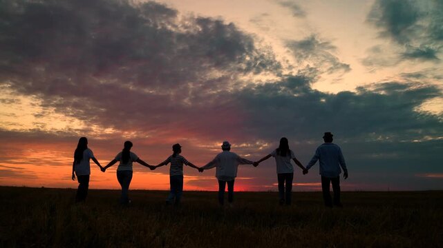 Human resources. Group of businesspeople walk hand in hand, nature. Business community teamwork, nature sunset. Group of businesspeople outdoors. Unity among group of people united by idea teamwork