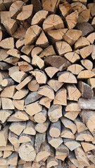 Fototapeta premium Stack of firewood forming a textured background, renewable energy source