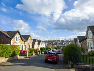 A residential area, in an urban or suburban setting, a mix of housing types and styles, a combination of taller apartment buildings and rows of houses with pitched roofs, a blend of architectural. 