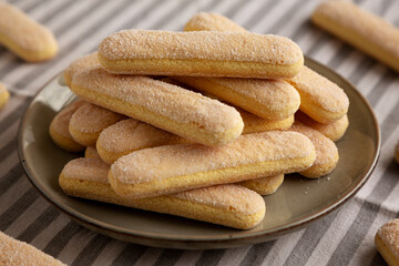 Savoiardi biscuits on a plate, side view.