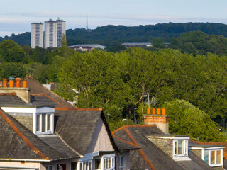 Multi-story residential buildings, apartments, townhouses, with varying architectural styles and colors. Green areas. High-rise residential tower blocks. Degree of landscaping or natural elements. 