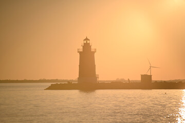 Silhouette Delaware Breakwater East End Lighthouse at Cape Henlopen at Sunset at Sunset with Windmill