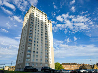 A tall, modern building,  a residential apartment building block, shot from a low angle looking...