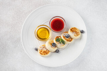 Syrniki with honey and berry sauce