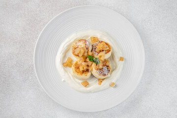 Homemade syrniki with cream and fruit topping