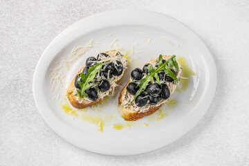 Bruschetta with black olives and arugula