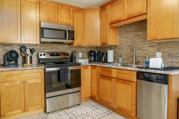 Fototapeta premium Modern kitchen wood cabinets stainless steel appliances