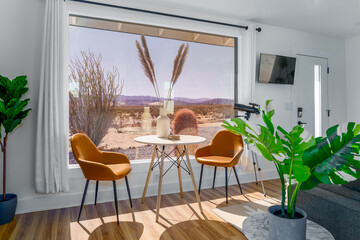 modern home with table chairs plants large window with a desert view joshua tree california