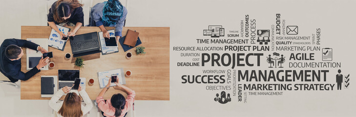A diverse team collaborates at a wooden table, utilizing laptops and documents to strategize...