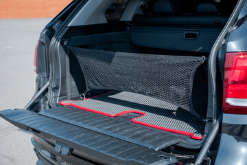 Black SUV with opened trunk hatch. Vehicle cargo space with organizer nets.