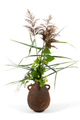 Handmade ceramic vase with a bouquet isolated on white background.