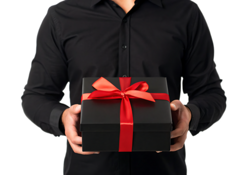 A person in a black shirt holding a black gift box with a red ribbon in front of a white background