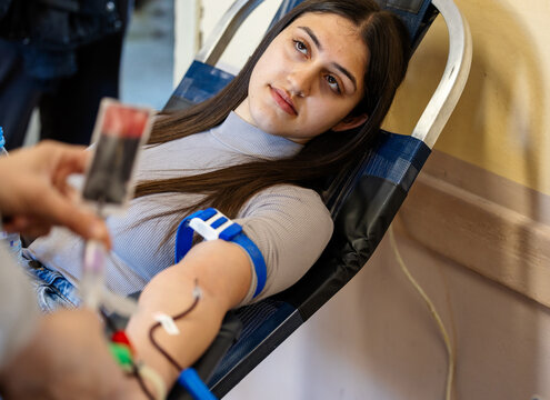 Young woman donates blood at local donation center - Powered by Adobe