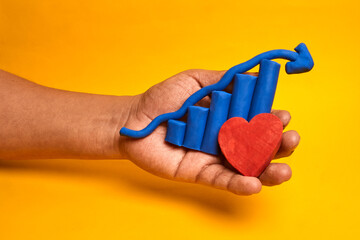 A hand holding a rising chart with a heart depicts customer loyalty driving growth, representing human centered strategy and brand affection.
