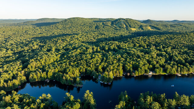 web, new york, usa - july 22, 2025: afternoon aerial summer image of the hamlet of old forge and surrounding lakes and forests.