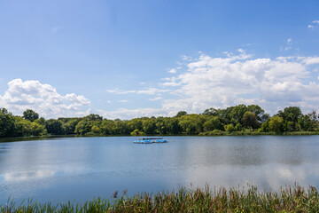 A lake surrounded by lush green trees and grass at FDR Park in Philadelphia Pennsylvania USA
