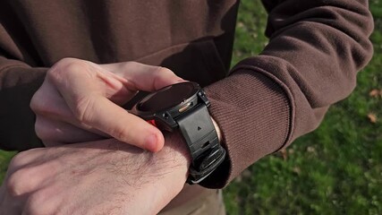 Man Using Fitness Watch Outdoors Before Workout. Boy checking fitness smartwatch