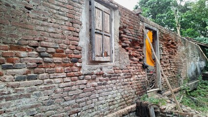 Artistic photo of a rustic brick wall with an old wooden window and weathered textures. Perfect for vintage backgrounds, retro design, historic architecture, and urban exploration themes.